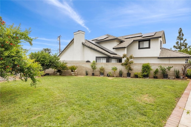 4950 N Treanor Ave, Covina, CA 91724 - view of side of property with stucco siding, roof mounted solar panels, a chimney, and a tile roof