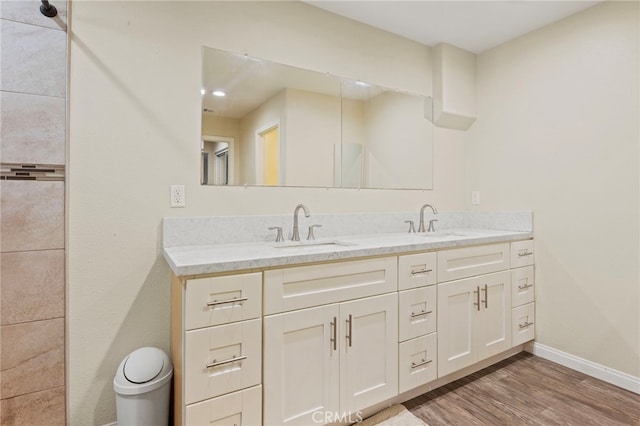 4950 N Treanor Ave, Covina, CA 91724 - bathroom featuring double vanity, wood finished floors, baseboards, and toilet