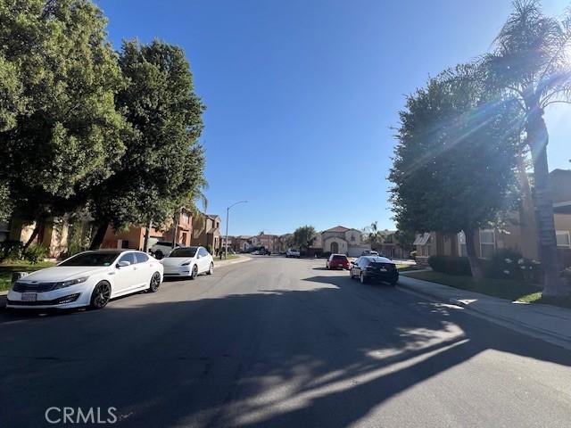 3762 Segovia Dr, Perris, CA 92571 - view of asphalt street featuring a residential view, street lights, curbs, and sidewalks