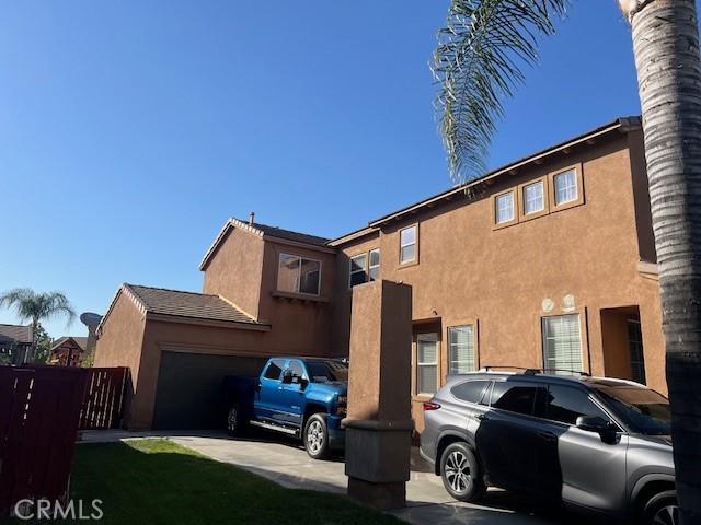 3762 Segovia Dr, Perris, CA 92571 - view of side of property featuring concrete driveway, stucco siding, and an attached garage