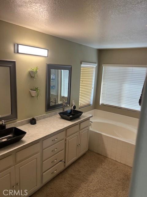 3762 Segovia Dr, Perris, CA 92571 - full bathroom featuring a textured ceiling, double vanity, and a bath