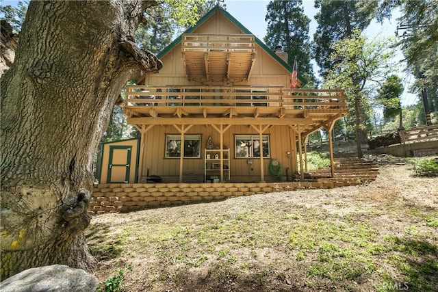 1213 Jungfrau Dr, Crestline, CA 92325 - rear view of house with a storage shed, a deck, a chimney, and board and batten siding