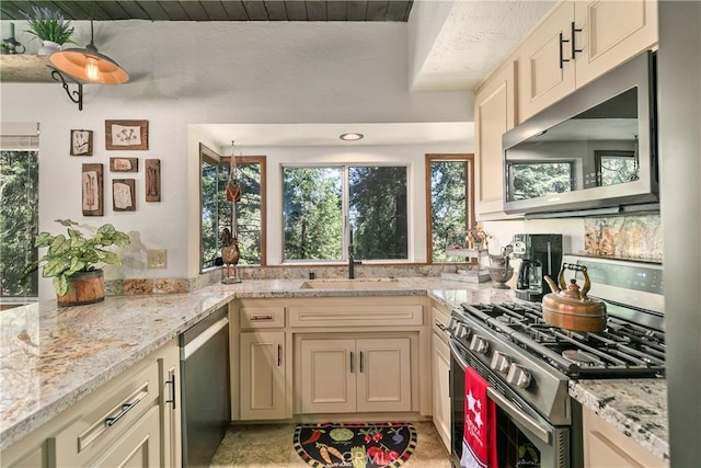 1213 Jungfrau Dr, Crestline, CA 92325 - kitchen with stainless steel appliances, plenty of natural light, cream cabinets, and light stone countertops