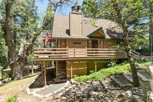 1213 Jungfrau Dr, Crestline, CA 92325 - back of house with roof with shingles, a deck, and a chimney