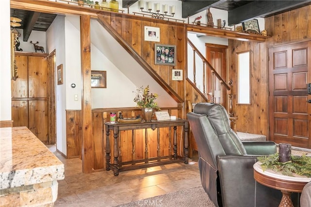 1213 Jungfrau Dr, Crestline, CA 92325 - living room featuring wooden walls, beamed ceiling, stairs, and a wainscoted wall