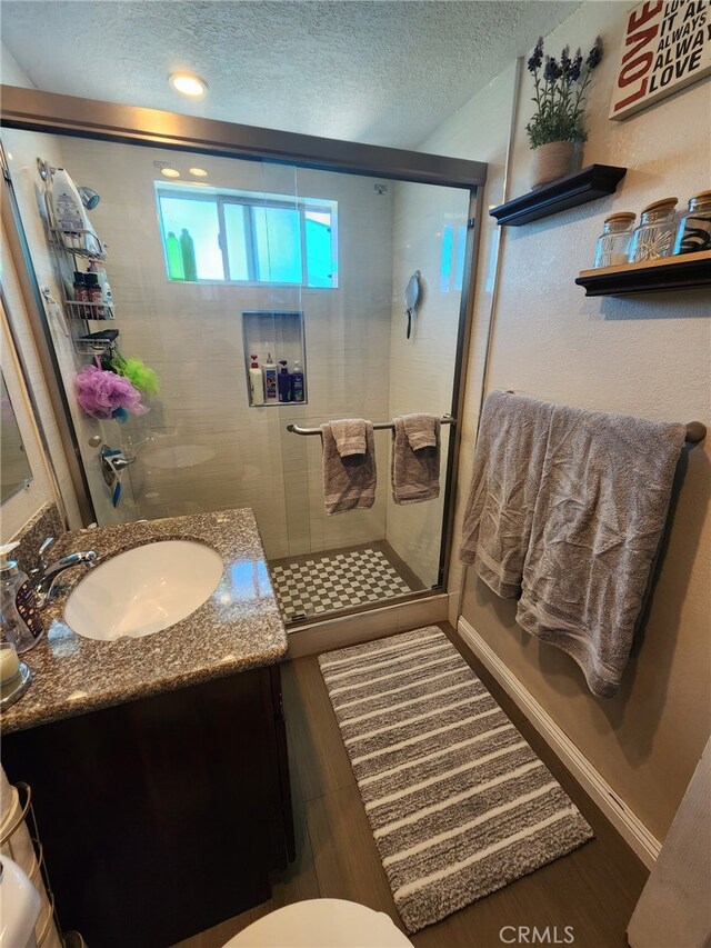 1417 Batson Ave, Rowland Heights, CA 91748 - bathroom with a textured ceiling, vanity, wood finished floors, a stall shower, and toilet