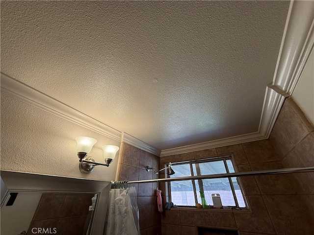 2309 W Anahurst Pl, Santa Ana, CA 92704 - bathroom view of tiled shower, crown molding, and a textured ceiling