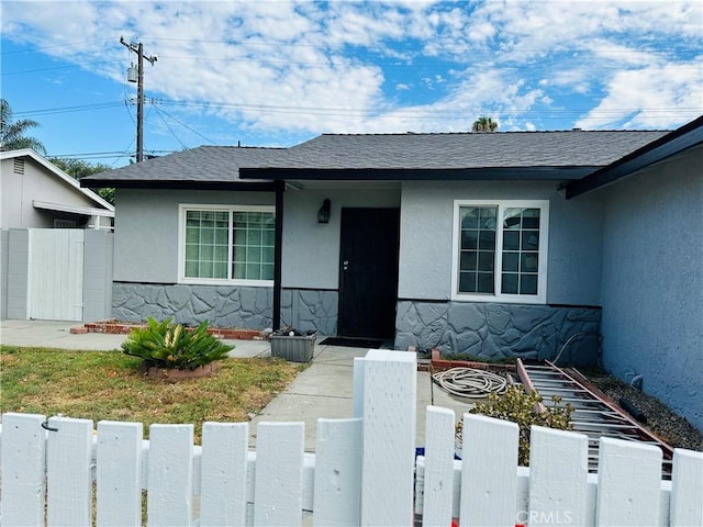 2309 W Anahurst Pl, Santa Ana, CA 92704 - view of front facade with stucco siding, a fenced front yard, a shingled roof, and a gate