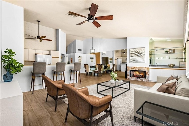 41810 Woodhaven Dr E, Palm Desert, CA 92211 - living area with ceiling fan, wood finished floors, a fireplace, and high vaulted ceiling
