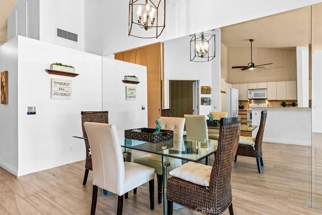 41810 Woodhaven Dr E, Palm Desert, CA 92211 - dining room featuring high vaulted ceiling, a chandelier, ceiling fan, baseboards, and light wood-style floors