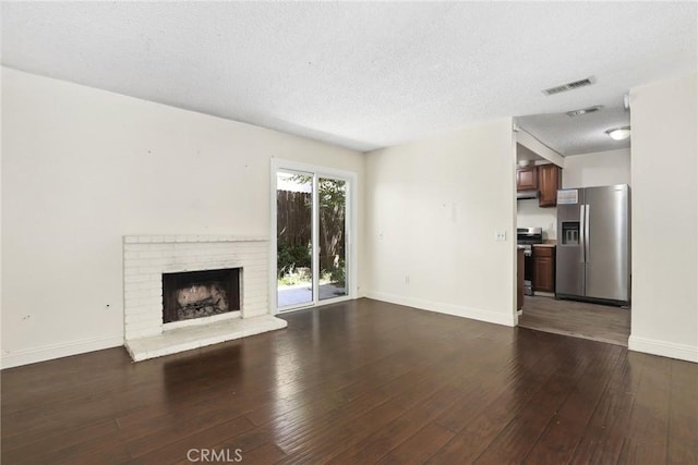 12828 Ramona Blvd Unit 54, Baldwin Park, CA 91706 - unfurnished living room featuring a textured ceiling, dark wood-style floors, baseboards, and a brick fireplace