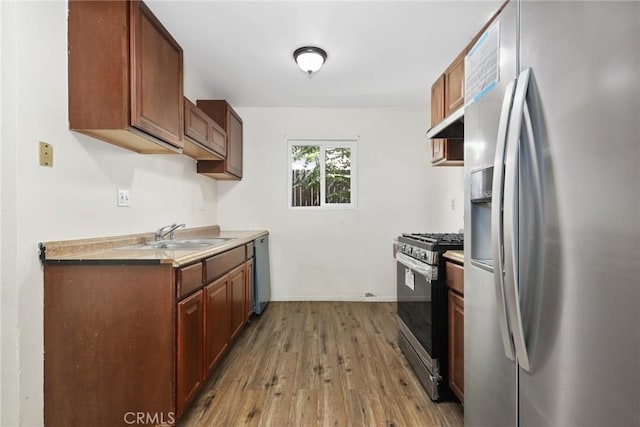 12828 Ramona Blvd Unit 54, Baldwin Park, CA 91706 - kitchen featuring appliances with stainless steel finishes, a sink, wood finished floors, under cabinet range hood, and light countertops