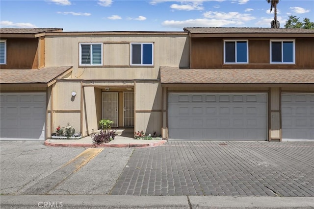 12828 Ramona Blvd Unit 54, Baldwin Park, CA 91706 - view of property with a garage and a shingled roof