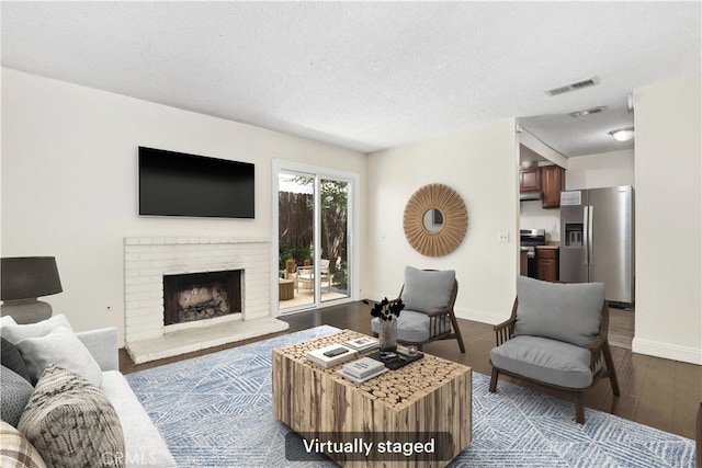 12828 Ramona Blvd Unit 54, Baldwin Park, CA 91706 - living room featuring wood finished floors, a textured ceiling, baseboards, and a fireplace