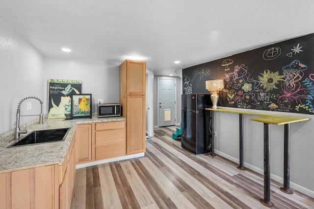 2042 Pheasant Run, Fallbrook, CA 92028 - kitchen with stainless steel microwave, light wood-style floors, light brown cabinetry, a textured ceiling, and recessed lighting