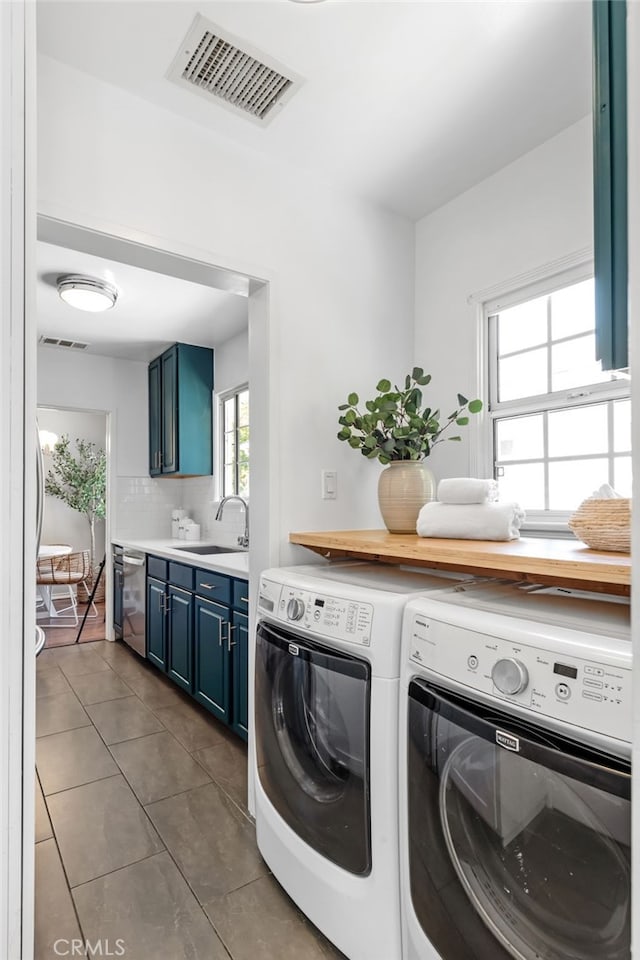 4146 Michael Ave, Los Angeles, CA 90066 - laundry room featuring separate washer and dryer, dark tile patterned floors, and cabinet space