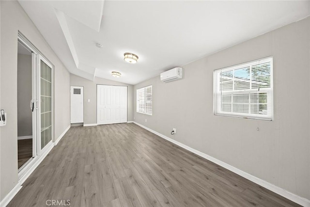 406 E Graves Ave, Monterey Park, CA 91755 - unfurnished bedroom with multiple windows, wood finished floors, lofted ceiling, baseboards, and a wall mounted AC