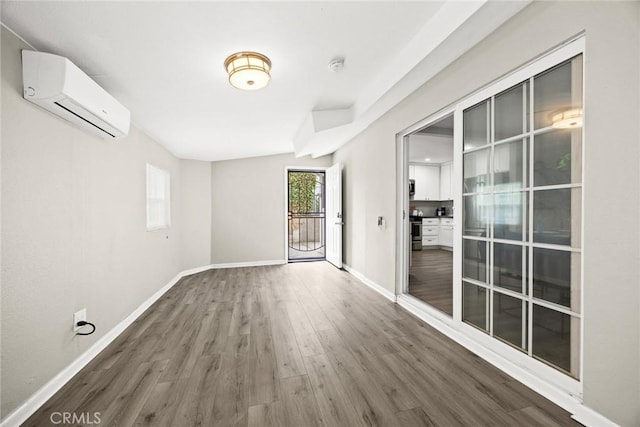 406 E Graves Ave, Monterey Park, CA 91755 - spare room with an AC wall unit, wood finished floors, and baseboards
