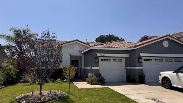 7256 Plumrose St, Fontana, CA 92336 - view of front of home featuring a garage, driveway, a tiled roof, a front lawn, and stucco siding