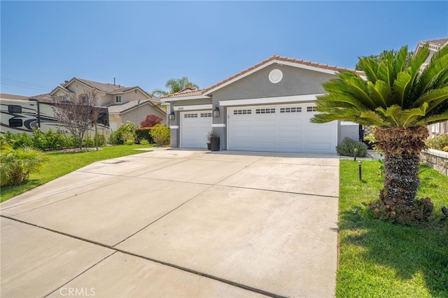 7256 Plumrose St, Fontana, CA 92336 - view of front of house featuring stucco siding, an attached garage, driveway, a tiled roof, and a front yard