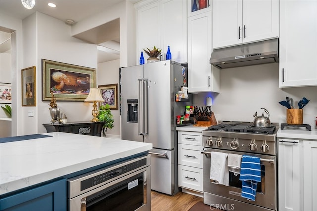 7256 Plumrose St, Fontana, CA 92336 - kitchen featuring appliances with stainless steel finishes, under cabinet range hood, white cabinets, light wood-style flooring, and recessed lighting