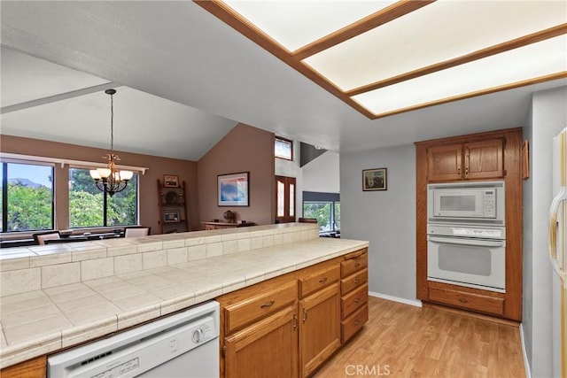 1555 Cordova Dr, San Luis Obispo, CA 93405 - kitchen featuring white appliances, a chandelier, vaulted ceiling, light wood-type flooring, and decorative light fixtures