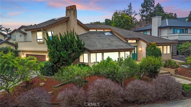 1555 Cordova Dr, San Luis Obispo, CA 93405 - back of property featuring a chimney, stucco siding, a garage, and a tiled roof
