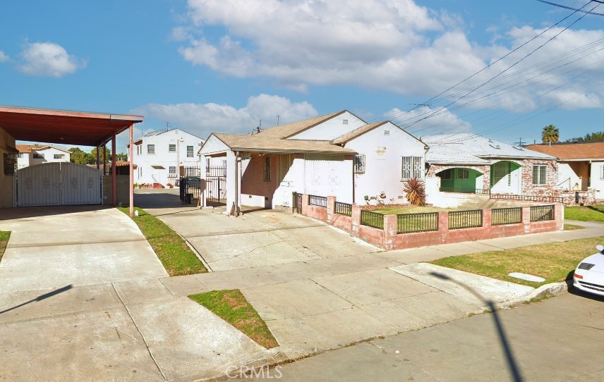 831 W 97th St, Los Angeles, CA 90044 - view of front of property featuring a fenced front yard, a gate, driveway, stucco siding, and a residential view