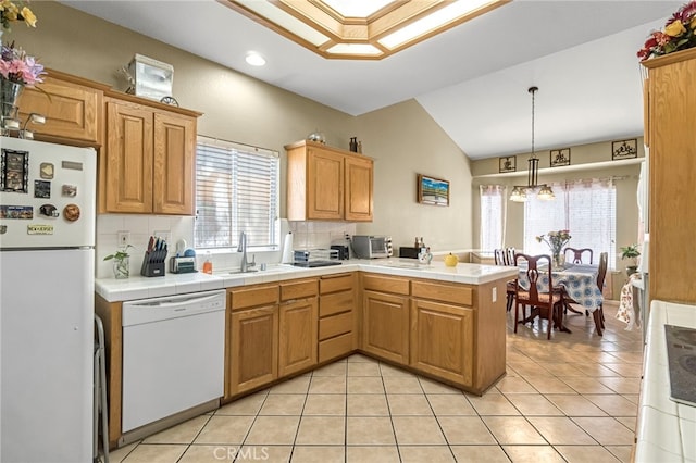 10033 N Baird Ave, Fresno, CA 93730 - kitchen with white appliances, a peninsula, lofted ceiling, healthy amount of natural light, and light tile patterned flooring