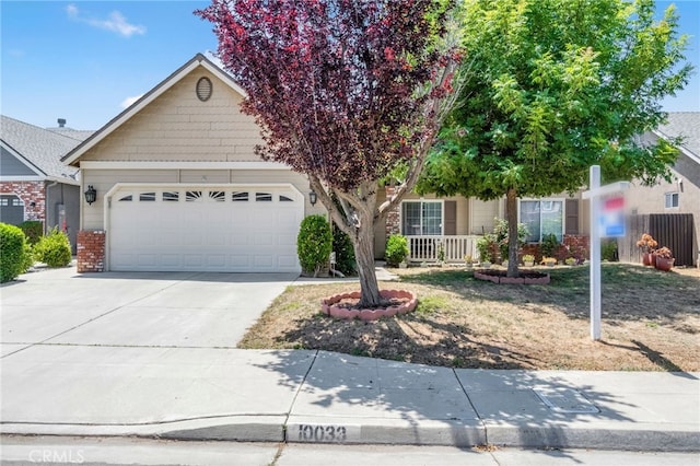10033 N Baird Ave, Fresno, CA 93730 - obstructed view of property featuring driveway, a garage, and brick siding