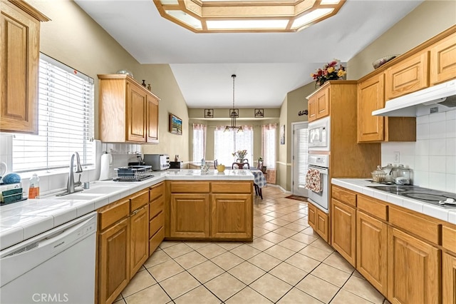 10033 N Baird Ave, Fresno, CA 93730 - kitchen featuring white appliances, a peninsula, tasteful backsplash, light tile patterned flooring, and under cabinet range hood