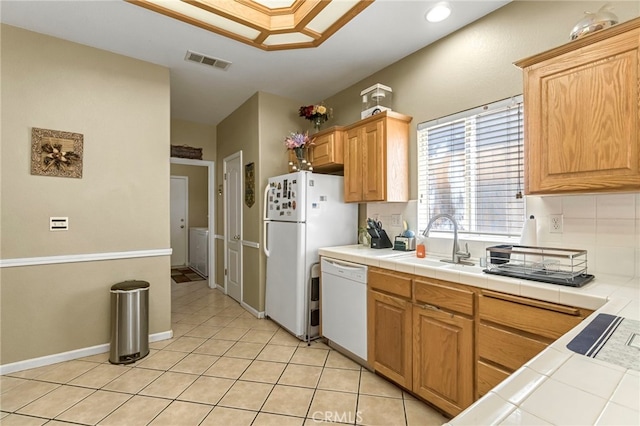 10033 N Baird Ave, Fresno, CA 93730 - kitchen featuring white appliances, tile counters, light tile patterned floors, tasteful backsplash, and washer / clothes dryer