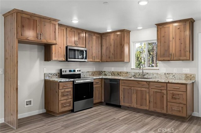 5821 Copeland Rd, Paradise, CA 95969 - kitchen featuring stainless steel appliances, a sink, baseboards, light wood-type flooring, and light stone counters