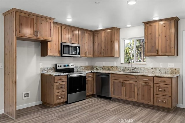 5821 Copeland Rd, Paradise, CA 95969 - kitchen with appliances with stainless steel finishes, light wood-style floors, light stone counters, brown cabinets, and recessed lighting