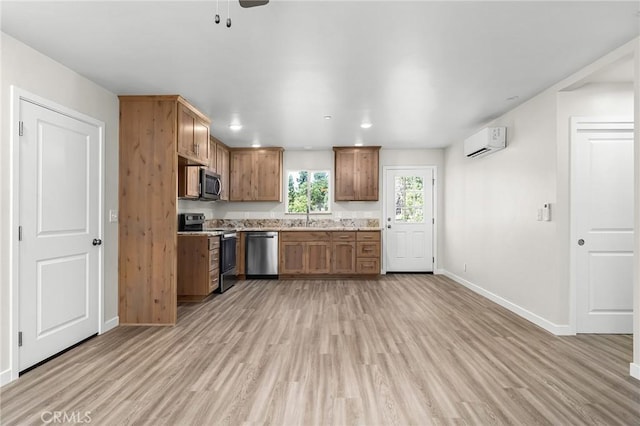 5821 Copeland Rd, Paradise, CA 95969 - kitchen with appliances with stainless steel finishes, a wall mounted AC, light wood-style flooring, baseboards, and a sink