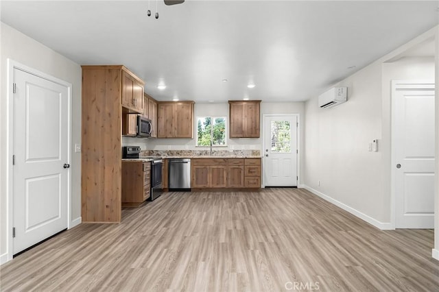 5821 Copeland Rd, Paradise, CA 95969 - kitchen with appliances with stainless steel finishes, a wall unit AC, light wood-type flooring, and brown cabinets