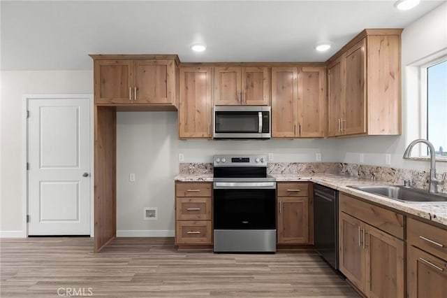 5821 Copeland Rd, Paradise, CA 95969 - kitchen featuring appliances with stainless steel finishes, a sink, light wood-style flooring, light stone countertops, and recessed lighting