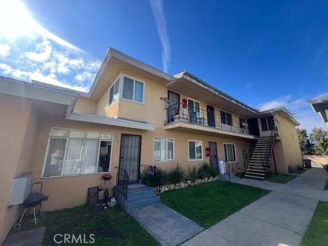 2809 W 141st Pl Unit 1, Gardena, CA 90249 - view of front of home featuring stucco siding, stairs, and a front lawn