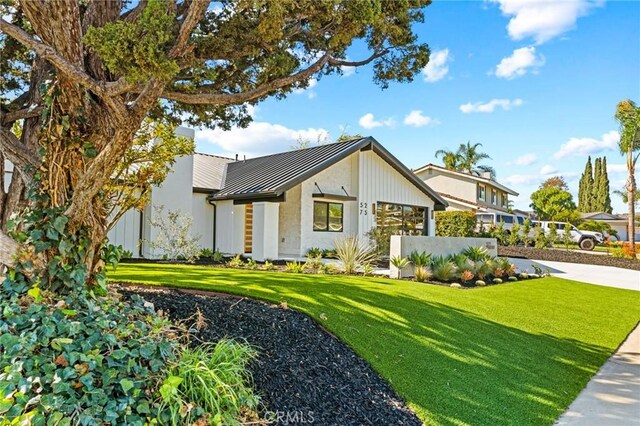 5275 Lynridge Dr, Yorba Linda, CA 92886 - view of front facade featuring a front lawn, a standing seam roof, metal roof, and stucco siding