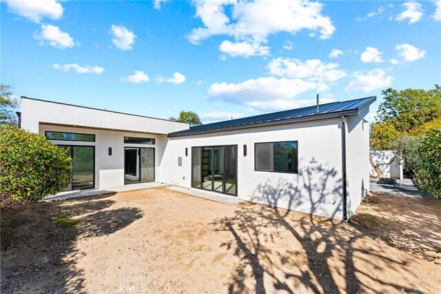 5275 Lynridge Dr, Yorba Linda, CA 92886 - back of property featuring stucco siding, a patio area, a standing seam roof, and metal roof