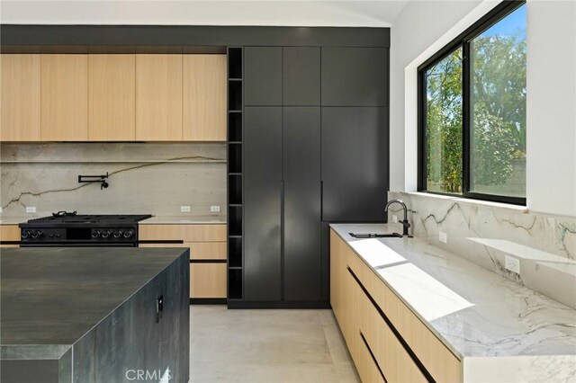 5275 Lynridge Dr, Yorba Linda, CA 92886 - kitchen with black range, a sink, modern cabinets, decorative backsplash, and light stone countertops