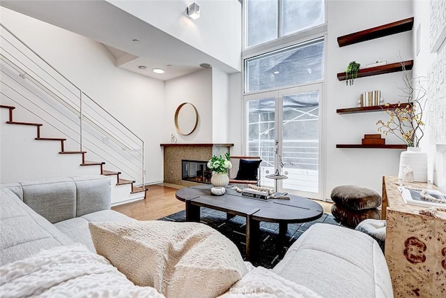 1436 N Detroit St Unit 2, Los Angeles, CA 90046 - living area featuring wood finished floors, a fireplace with flush hearth, stairway, a high ceiling, and baseboards