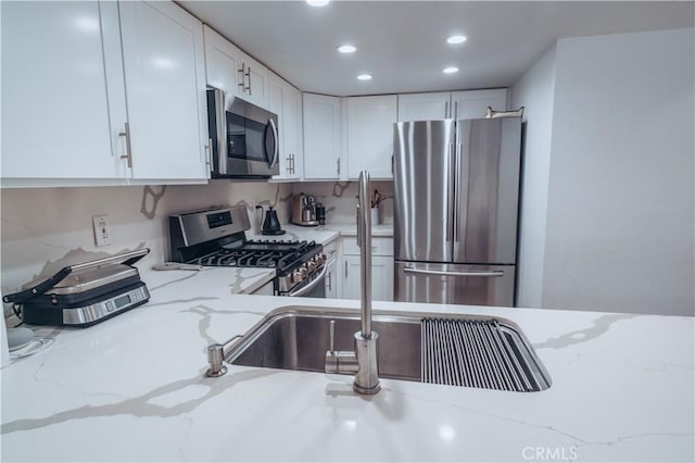 25598 Mont Pointe Unit 4E, Lake Forest, CA 92630 - kitchen with stainless steel appliances, recessed lighting, white cabinetry, and light stone counters