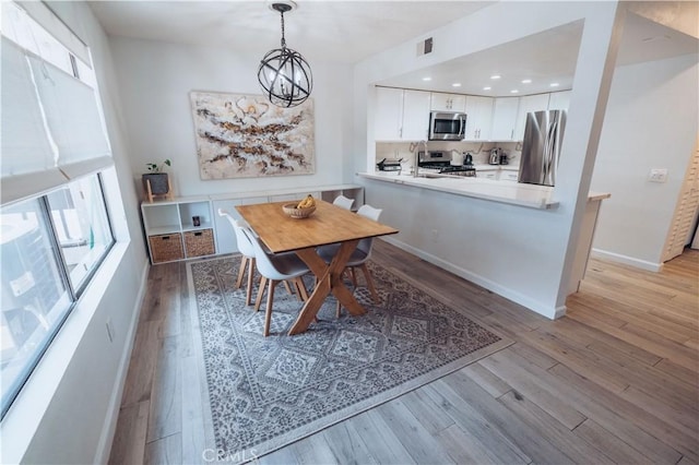 25598 Mont Pointe Unit 4E, Lake Forest, CA 92630 - dining area featuring healthy amount of natural light, light wood finished floors, and a chandelier