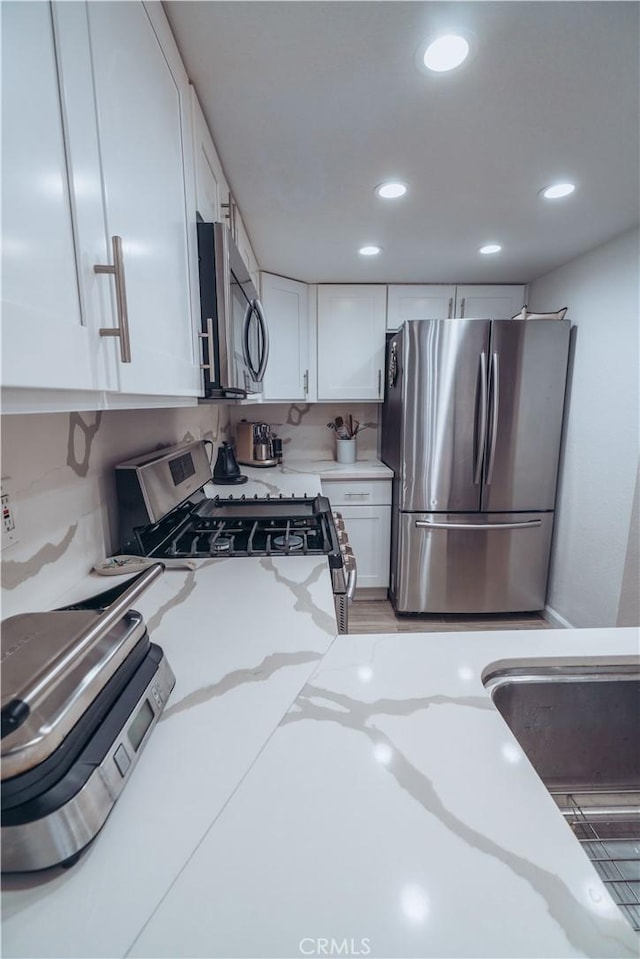 25598 Mont Pointe Unit 4E, Lake Forest, CA 92630 - kitchen featuring stainless steel appliances, white cabinets, recessed lighting, and light stone countertops