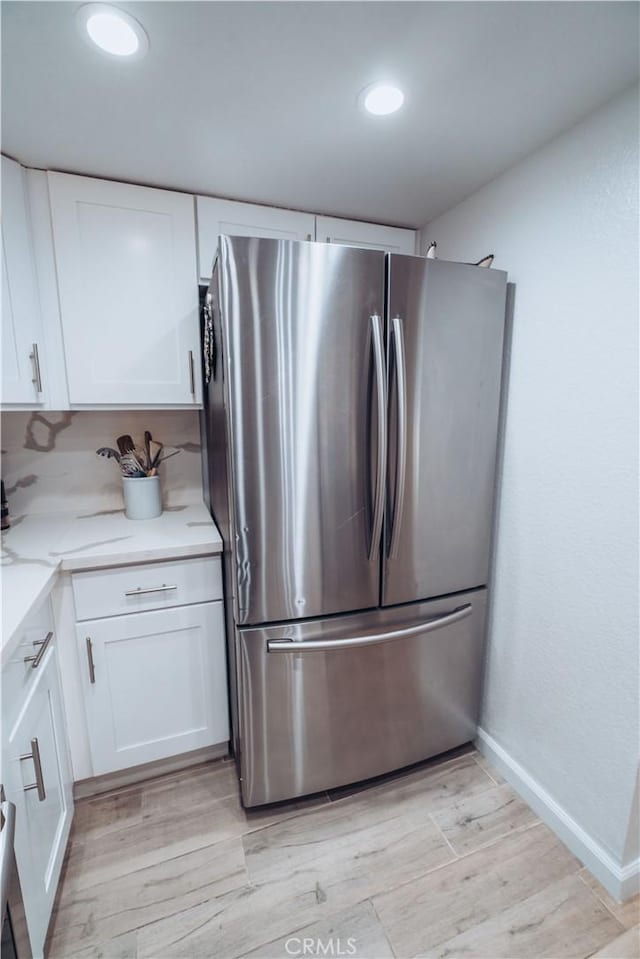 25598 Mont Pointe Unit 4E, Lake Forest, CA 92630 - kitchen with freestanding refrigerator, white cabinetry, light wood finished floors, recessed lighting, and light stone countertops