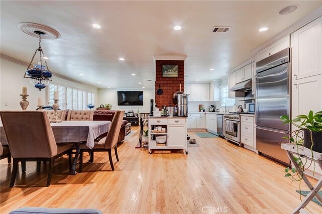 12438 Lambert Cir, Garden Grove, CA 92841 - kitchen featuring high end appliances, under cabinet range hood, white cabinetry, light wood-style flooring, and recessed lighting