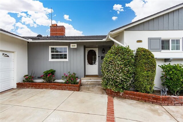 12438 Lambert Cir, Garden Grove, CA 92841 - view of exterior entry with a chimney and a shingled roof