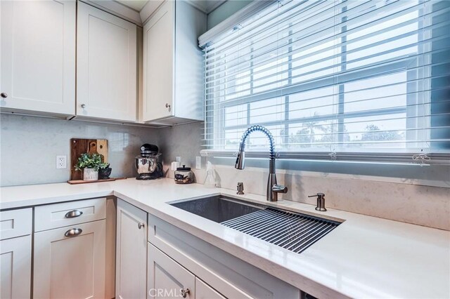 12438 Lambert Cir, Garden Grove, CA 92841 - kitchen featuring a sink, light countertops, plenty of natural light, and white cabinetry