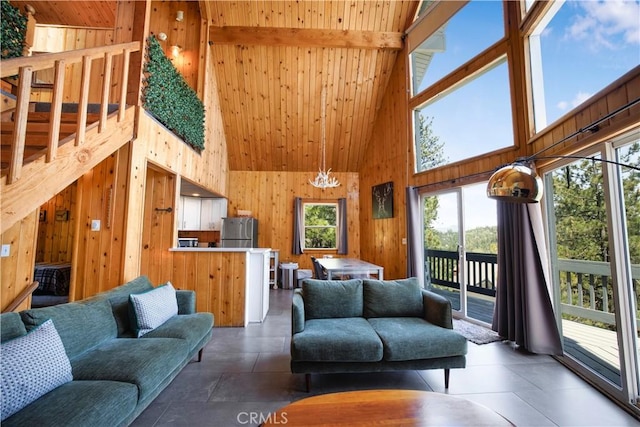 26503 Amador Ln, Lake Arrowhead, CA 92352 - living area with high vaulted ceiling, wood walls, wood ceiling with exposed beams, and a chandelier